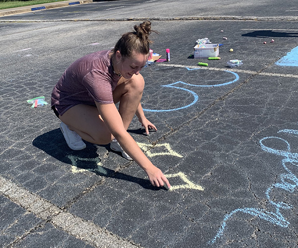 Senior Victoria Wiest decorates a parking spot with chalk on the Sunday before the first day of school. This day marks the beginning of the class of 2021’s last year at Starr’s Mill. 