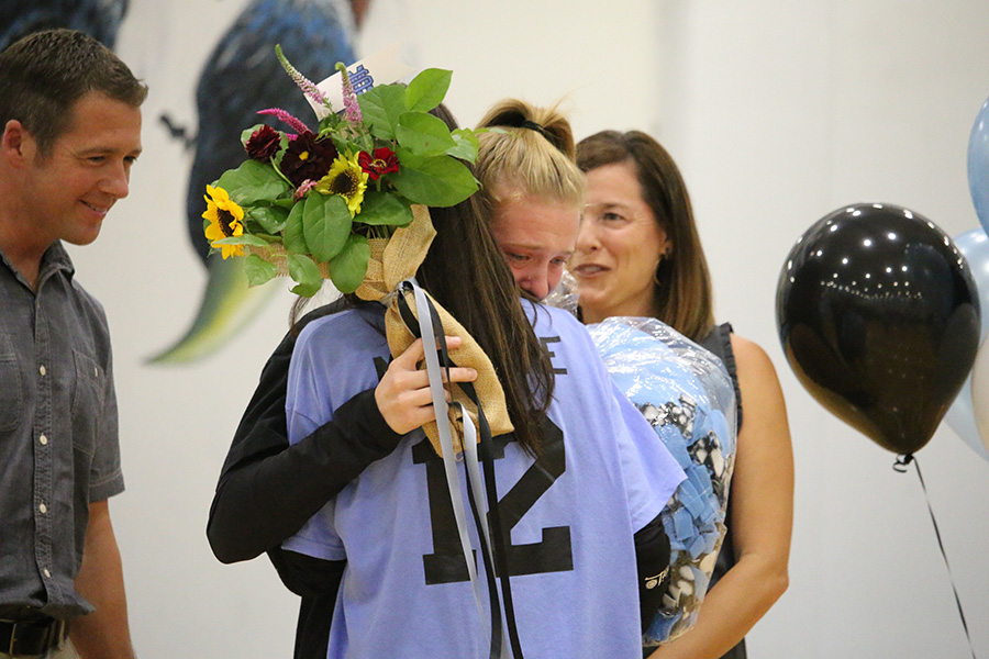 Senior Ashlyn Mercure hugs her sister, sophomore Elise Mercure, during the senior night ceremony. “It’s sad [that it’s my last year], but I’m glad I got to spend the last four years with this team,” Ashlyn said. 