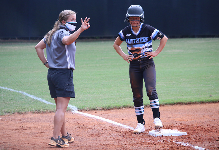 Coach Peyton Dean signals across the field as senior Lauren Flanders waits on the third base. This is Dean’s first year at Starr’s Mill High School after teaching at Rising Starr Middle School. She graduated from Armstrong State University, where she majored in health and physical science.