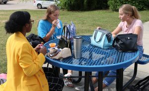 Sophomores Ivey Breinig, Mia Haefner, and Alaina Campbell (left to right) eat lunch on the patio outside of the cafeteria. Students and faculty have been making adjustments in preparation for switching from the “yellow” hybrid A/B schedule to “green” merged schedule. The change takes effect Oct. 19 and includes switching from three to four lunch periods.