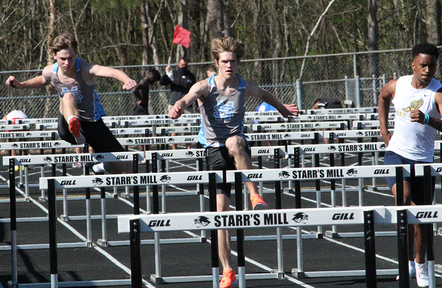 Ryan Barch (left) and junior David Bowers (right) jump over hurdles. Barch and Bowers ran the 110 meter hurdles in 19.11 seconds and 18.61, respectively. They placed 17th and 15th overall.