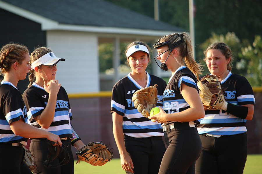 Lady Panthers gather to talk to senior pitcher Lili Backes (99) before a pitch. In a 6-1 loss, Backes gave up six runs on nine hits with eight strikeouts total.