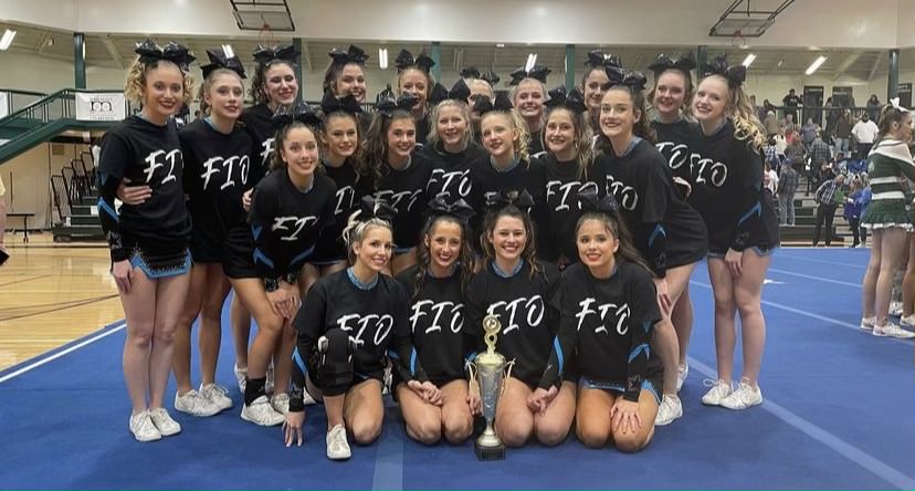 Varsity cheer team poses with first place trophy after competing at McIntosh High School. A total of eight teams competed. 