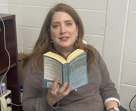 English teacher Nancy Close holds up one of her favorite books, “A Prayer from Owen Meany.” The book is about two best friends living life together during the 1950s.