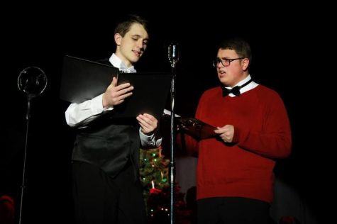 Junior Matthew Little (left), playing radio show host, Freddy Filmore, and junior Jacob Love (right), playing Clarence the Angel, stand in front of the microphone. For their Christmas show, the Starr’s Mill drama department presented “It’s A Wonderful Life” in the form of a radio show.