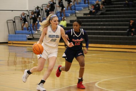 Senior Jaclyn Hester (22) moves the ball up the court as a Northside player defends. Despite multiple attempts to capitalize on the Patriot lead, the Starr’s Mill Lady Panthers lost 74-55.