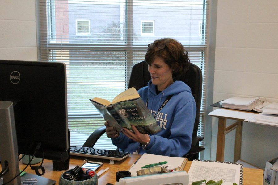 Math teacher Julie Spencer sits at her desk reading “All the Light We Cannot See” by Anthony Doerr. The book focuses on the life of a young girl during World War II. 