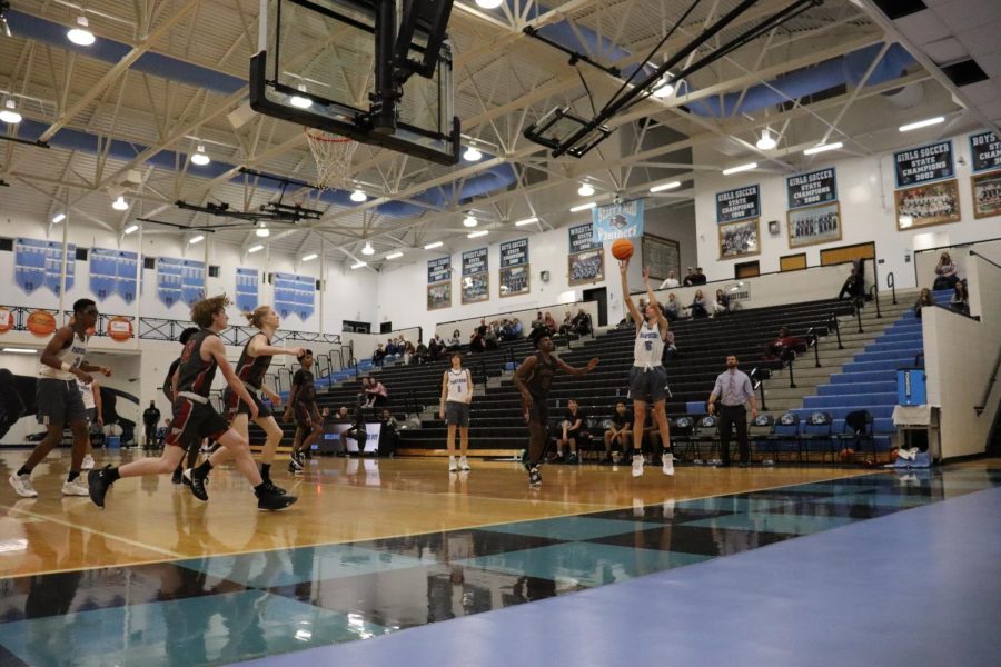 Johnny Tucker shoots a jump shot against Whitewater. Throughout the season, the team grew and learned to work more efficiently as a team.