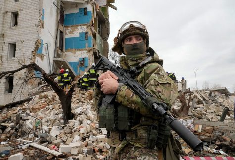 Ukrainian soldier stands in the ruins of a building. The conflict has joined leagues of other crises that politicians use to avoid responsibility. 