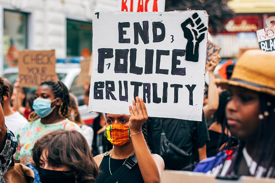 Man holds up a sign in protest to police brutality. As the amount of victims of police brutality climb, there becomes more of a need for justice. 