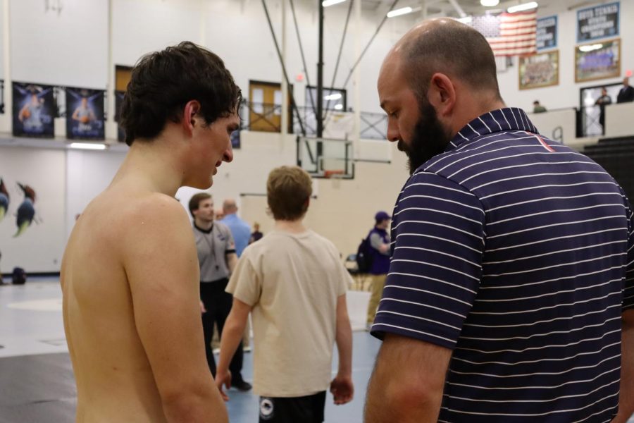 Coach Will Carter gives senior Preston Burrus a pep-talk after his injury. “Wrestling has taught me that if you put enough hard work in you’ll get what you want out of life,” Burrus said.