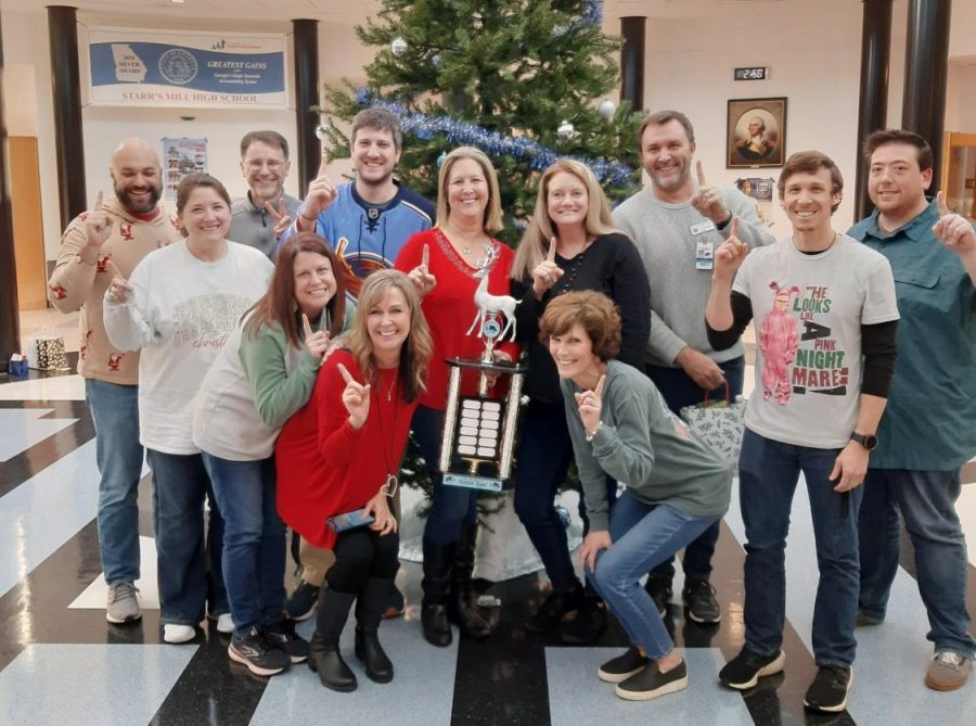 Members of the math department pose with the inaugural Reindeer Games cup. The Reindeer Games were a series of competitions among the teachers during exam week designed to boost morale and camaraderie within the departments.