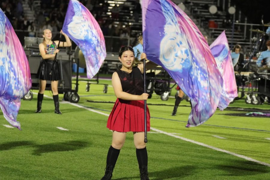 Senior Miho Kimura poses with her flag during a Starr’s Mill football game halftime show. With her hardworking attitude and distinct stage presence, Kimura successfully passed her audition to be part of the University of Alabama’s Million Dollar Marching Band. 
