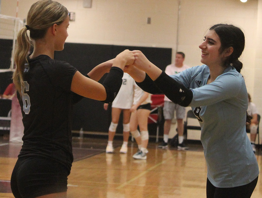 Junior Maci Morrow and sophomore Ellie Sills celebrate with a double fist-bump between sets. The team’s communication, teamwork, and positive energy led to their victory in the last three matches.
