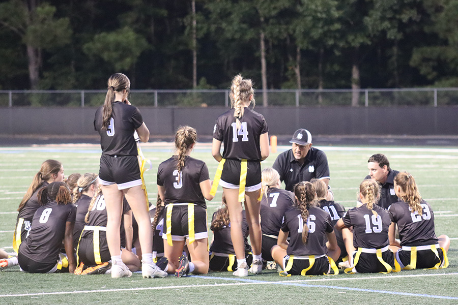 Head coach Mark Williamson talks with the varsity team following their loss to Langston Hughes, 20-0. Despite losing the scrimmage, the team continues to learn the game as the second season of the program begins.