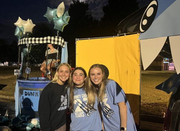 The swim teams set-up for Trunk or Treat. They set up a dunk booth and gave out candy. Junior Jacob Ramsey is in the dunk booth, and seniors Emma Frank, Sophia Cochran, Caroline Craddock are helping run the station. 