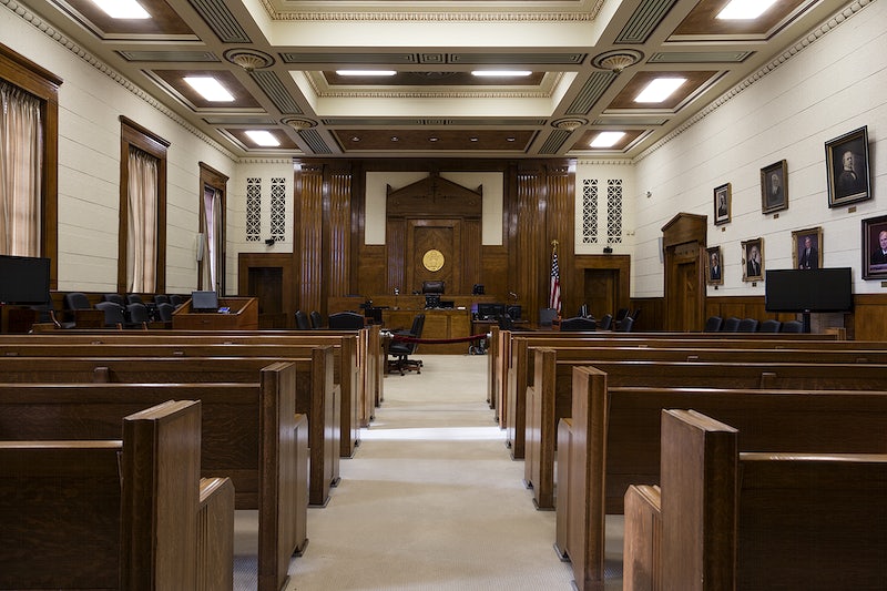 An empty courtroom sits awaiting its next case. Trials set inside should never be filmed at the risk of ridding someone of their dignity. We need to convince the large majority of the dangers before privacy disappears.