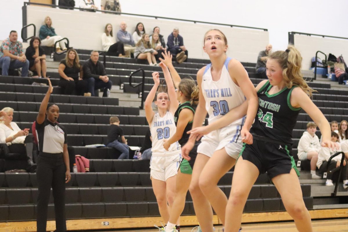 Freshman Lindsay Kopacek posts up against McIntosh’s sophomore Claudia Meditz while senior Brooke Godown shoots. A strong veteran-newcomer combination helped Starr’s Mill defeat the Lady Chiefs 45-29.