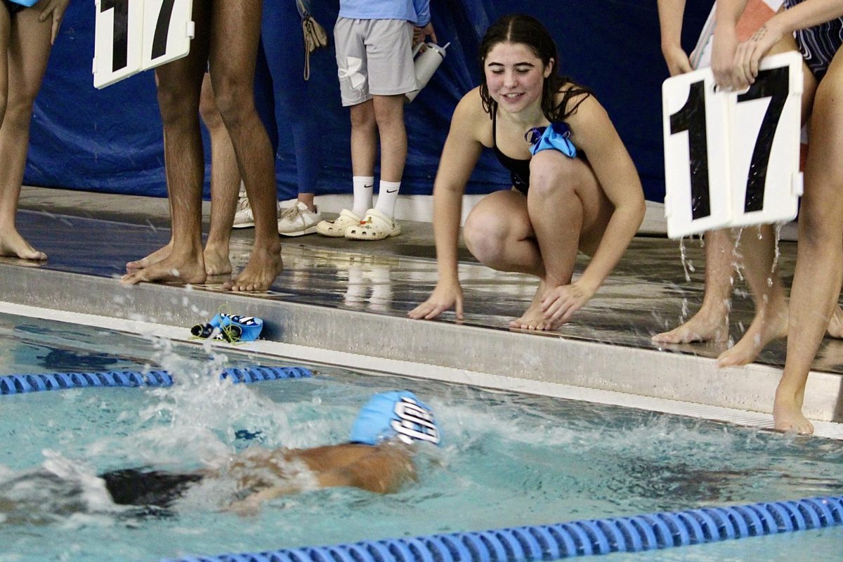 Senior Sophia Cochran cheers on senior Ishan Kasaju while he swims the 500-yard freestyle. She had qualified in the 200-yard freestyle with a time of 2 minutes, 4.33 seconds. The team recently defeated Sandy Creek and Fayette County.