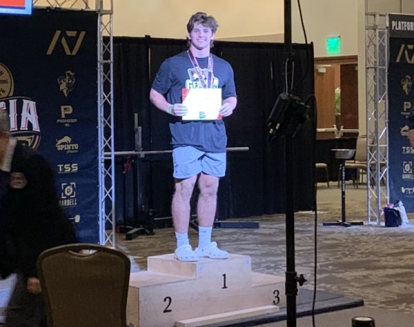 Turner stands on the podium holding his certificate after the USA Powerlifting Competition in Cartersville, Georgia. He competed in the open age category, placing 16th out of 40 men ranging from age 15 to 60. He set three state records for squat, bench press, and deadlift.