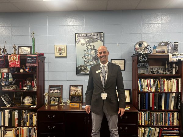 Principal Allen Leonard stands by a collection of some of his achievements and memorabilia during his time at Starr’s Mill. He will be moving on to a position in the county as Head of Transportation after finishing this school year.