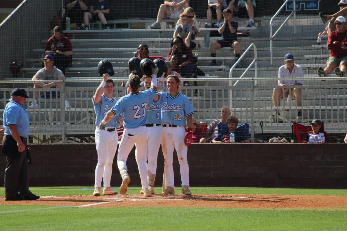 Seniors Max Prozny and Jack Ryan and sophomore Erik Lundstrum celebrate sophomore Brock Rein after a run. The Panthers beat the Cadets 11-1 and 14-0 in a double header last Wednesday.