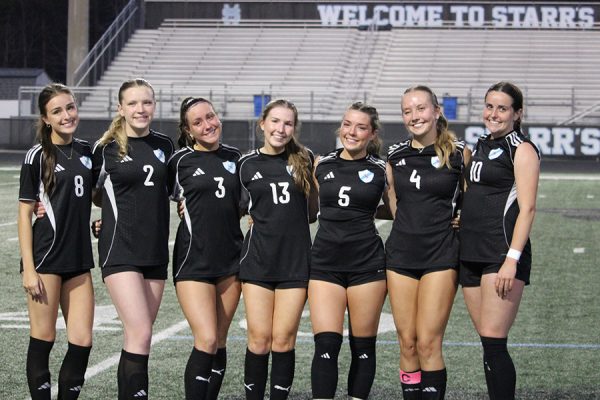 Seven senior varsity girls soccer players pose together. With no seniors on the boys varsity soccer team, only the girls were recognized in the senior ceremony after the game.