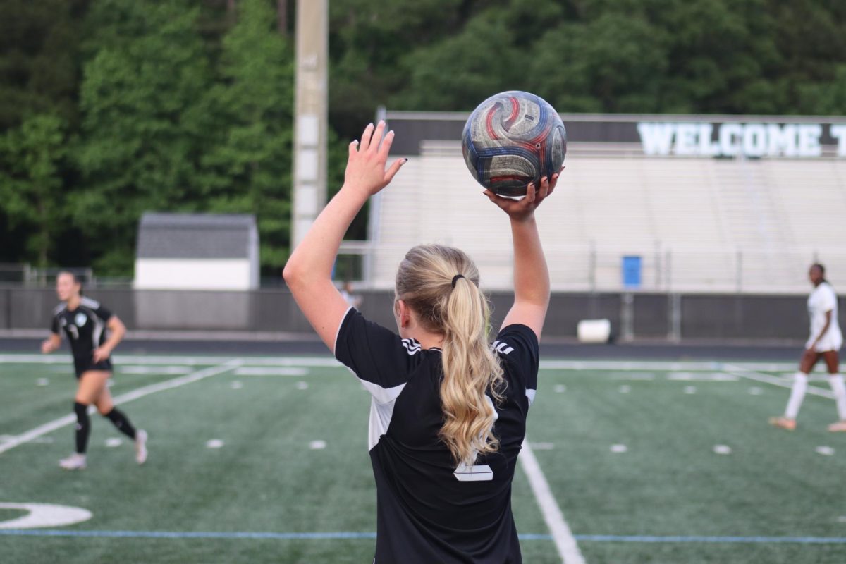 Senior Laura Randall throws the ball back into play. Despite earning several recognitions for the season, varsity girls soccer was eliminated from the playoffs after a second round loss to Westminster, 2-0.